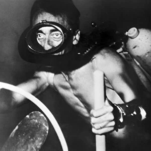JACQUES COUSTEAU (1910-1997). French oceanographer. Driving his underwater electric scooter in a scene from his film The Silent World, filmed in 1954-55 and released in 1956