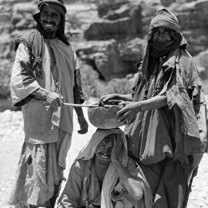 JORDAN: BEDOUIN RITUAL. Two Bedouins perform a healing ritual over a sick man, at Petra, Jordan
