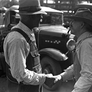 KANSAS: FARMERS, 1938. Two farmers shake hands at a farm auction in Oskaloosa, Kansas