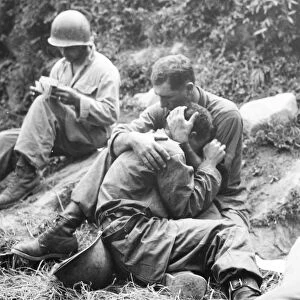 KOREAN WAR, 1950. An American infantryman comforted by a comrade upon learning of the death of a friend in battle, 1950