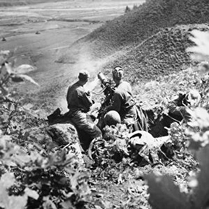 KOREAN WAR: MACHINE GUN. American soldiers man a machine gun on a hilltop position. Photographed 1951