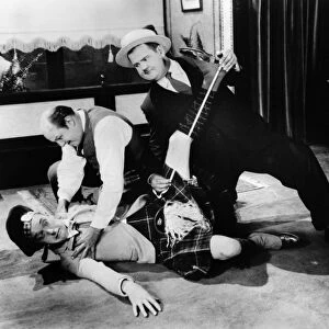 LAUREL AND HARDY, 1927. Stan Laurel (on floor) and Oliver Hardy (right) in a scene from Putting Pants on Philip, their first film as a comedy duo, 1927, directed by Hal Roach