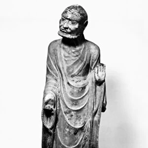 A lohan holding prayer beads in one hand, with the other raised in a preaching gesture. Marble. Height: 42 in. Jin Dynasty, northern China, 1180
