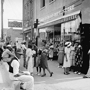 MAIN STREET SHOPPERS, 1939. African American men and women shopping and socializing