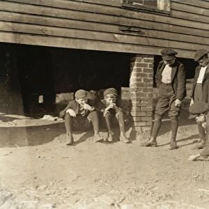MARBLE GAME, 1908. Group of boys shooting a game of marbles outside the cotton