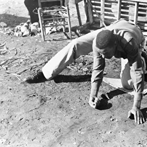 MARBLE GAME, 1940. An African American man playing a game of marbles. Photographed in Eufaula