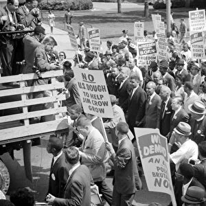 Martin Luther King, Jr. Roy Wilkins, and other civil rights leaders surrounded by crowds carrying signs at the March on Washington, 28 August 1963. Photographed by Warren K. Leffler