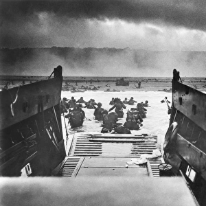Men of Company E, 16th Infantry Regiment, 1st U. S. Infantry Division, landing on Omaha Beach, Normandy, France, from the landing craft USS Samuel Chase on D-Day, 6 June 1944. Photographed by U. S. Coast Guard Chief Photographers Mate Robert F. Sargent