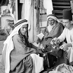MIDDLE EAST: BEDOUINS, 1932. A group of Bedouin men seated at a shop in the Middle East