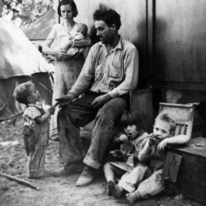 MIGRANT CAMP, 1935. An ex-tenant farmer from Texas with his family in a camp for