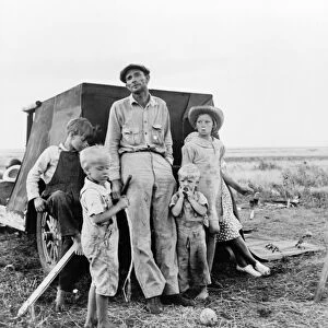 MIGRANT FAMILY, 1938. A migrant worker with his family camping on the outskirts of Perrytown