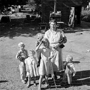 MIGRANT FAMILY, 1939. A mother and five children living in a shacktown community