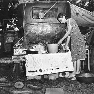 MIGRANT FAMILY, 1940. Wife of migrant worker from Arkansas preparing a meal at