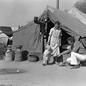 MIGRANT WORKERS, 1936. A family of drought refugees at a migrant camp in Kern County, California