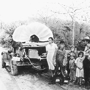 MIGRANT WORKERS, c1930. A family of fruit pickers from Oklahoma en route to Arkansas