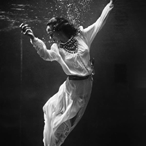 MODEL UNDERWATER, 1939. A fashion model underwater in a dolphin tank at Marineland, Florida