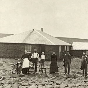 NEBRASKA: SETTLERS, c1885. Family of homesteaders, photographed outside of their sod house with a windmill on the roof of the adjoining building in Custer County, Nebraska. Photograph by Solomon D. Butcher, c1885