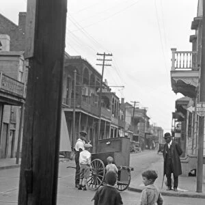 NEW ORLEANS, c1925. Children watching an organ grinder on the street corner in New Orleans