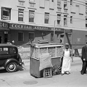 NEW YORK CITY, 1938. A peanut seller on Lenox Avenue and 133rd Street in Harlem, New York City