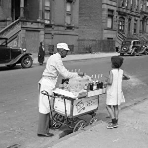 NEW YORK CITY, 1938. A shave ice seller on Lenox Avenue and 133rd Street in Harlem, New York City