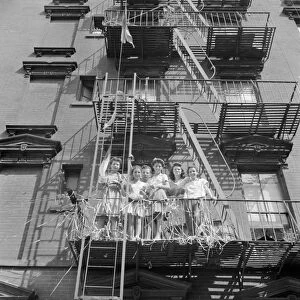 NEW YORK: MOTT STREET, 1942. Italian-American women on a fire escape watching a parade