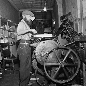 NEW YORK: PRINTER, 1942. A Jewish printer working on a printing press in a small