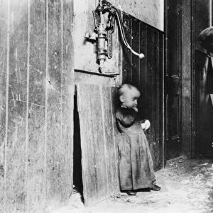 NYC: TENEMENT, c1890. A child standing in the hallway of a tenement building