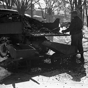 OHIO: COAL DELIVERY, 1940. A delivery worker shoveling coal from a pick-up truck