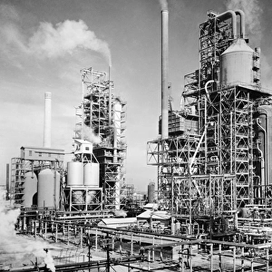 Three oil refinery units in Louisiania, which use the process of cracking, set up to supply fuel for allied units fighting in World War II. Photograph, c1944