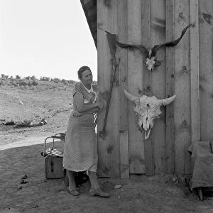 OREGON: FARM WIFE, 1939. A farmers wife standing beside two animal skulls