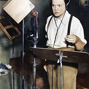 ORSON WELLES (1915-1985). American director, producer, screenwriter, and actor. Shown broadcasting his famous adaptation of H. G. Wells novel The War of the Worlds, 30 October 1938. Oil over a photograph