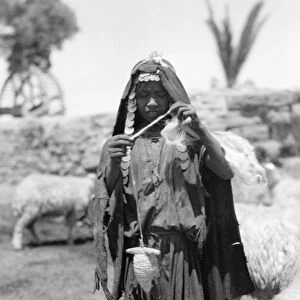 PALESTINE: BEDOUIN WOMAN. A Bedouin shepherd spinning yarn, in the Sharon region of Palestine