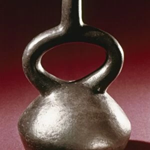 PERU: CHIMU JAR. Polished blackware stirrup jar, made by the Chimu culture of ancient Peru, 13th - 15th century