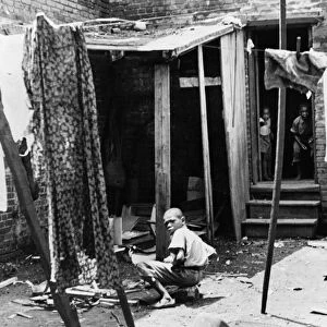 POVERTY: CHILDREN, 1935. Children in their backyard in the slum district of Washington, D