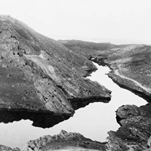 A river of crude oil flowing through the Kirkuk district of a Iraq, the result of an uncontrolled gusher in an oil field. Photograph, c1932
