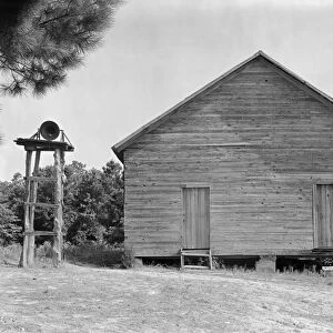 RURAL SCHOOLHOUSE, 1936. One-room grammar schoolhouse and school bell in Alabama
