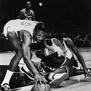 BILL RUSSELL (1934- ). American basketball player. Russell, playing for the Boston Celtics, reaching for a free ball rolling away from his teammate Sam Jones and Leroy Ellis of the L. A. Lakers during a game at Madison Square Garden in New York City, November 1963