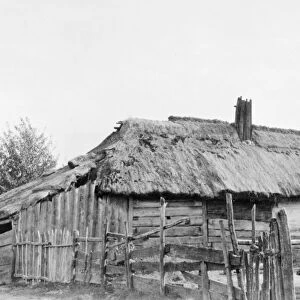 RUSSIA: LOG HOUSE, c1918. A peasants log house with thatched roof. Photograph, c1918