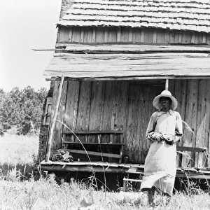 SHARECROPPER, 1937. Sharecroppers wife standing in front of a cabin south of Jackson