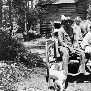 SHARECROPPER, 1939. A sharecropper and his children returning home after stringing