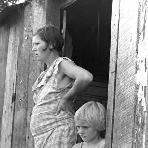 SHARECROPPERs WIFE, 1935. Pregnant mother and child of a sharecropped in their shack
