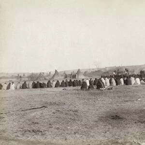 SIOUX COUNCIL, 1891. Rear view of a group of Lakota Sioux men, seated on the ground