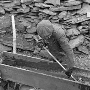 SOUTH DAKOTA: MINING, 1938. A gold miner working in sluice box at Two Bit Creek, South Dakota
