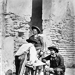 SPAIN: COWBOYS, c1875. Three Spanish cowboys around a outdoor table in Cordoba, Spain