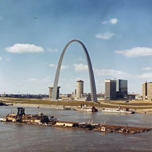 ST. LOUIS: WATERFRONT. A dredge of the U. S. Army Corps of Engineers passing the Gateway Arch on the Mississippi River waterfront in St. Louis, Missouri. Photographed c1973