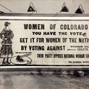 SUFFRAGE BILLBOARD, 1916. A suffragette putting up a National Womans Party billboard