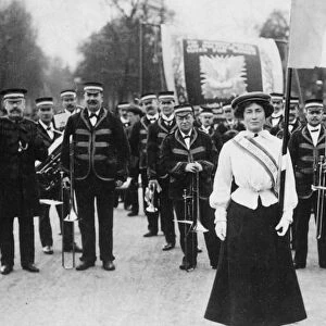 SUFFRAGETTE PARADE, 1908. Daisy Dugdale bears the standard in a procession at London