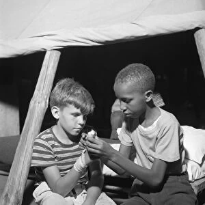 SUMMER CAMP, 1943. Campers practicing first aid at Camp Nathan Hale, an interracial