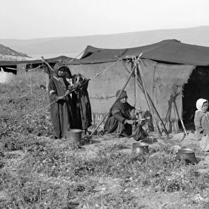 SYRIA: BEDOUIN CAMP, c1936. A Bedouin woman churning butter with children outside