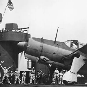 A take-off signal officer gives a fighter plane the Go sign on board the military aircraft carrier, USS Yorktown, in a scene from the American propaganda film, The Fighting Lady, 1944